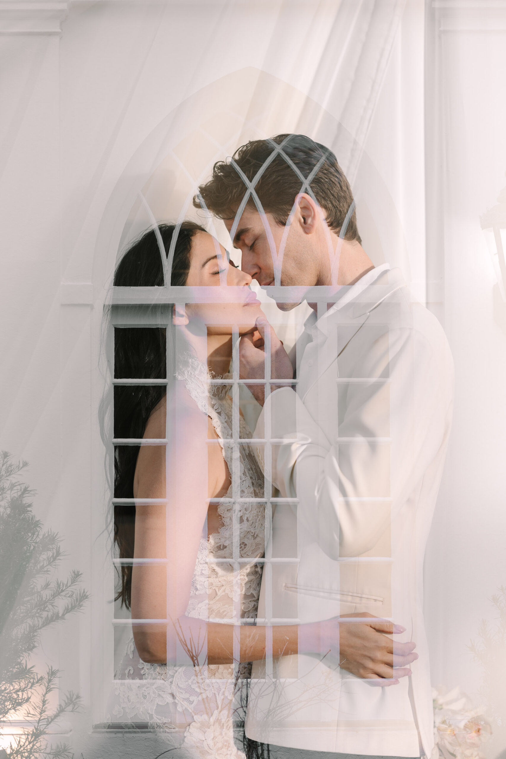 Romantic bride and groom embracing through a window at Lowndes Grove in Charleston, South Carolina captured with soft light by Stee Garman Photography Charleston wedding photographer.