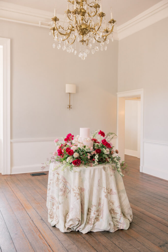Floral reception table beneath a crystal chandelier inside a softly lit ballroom at an elegant downtown Columbia SC wedding venue.