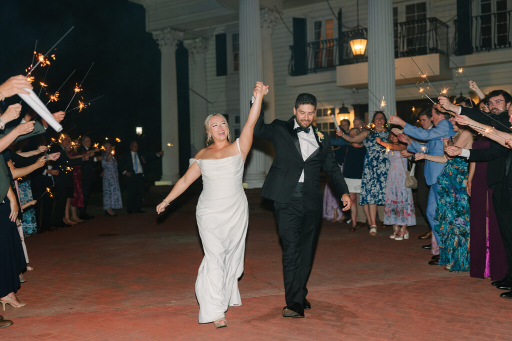 The newlyweds make a spirited entrance across the estate courtyard at night, closing the evening with classic Grand Holland Estate wedding style.