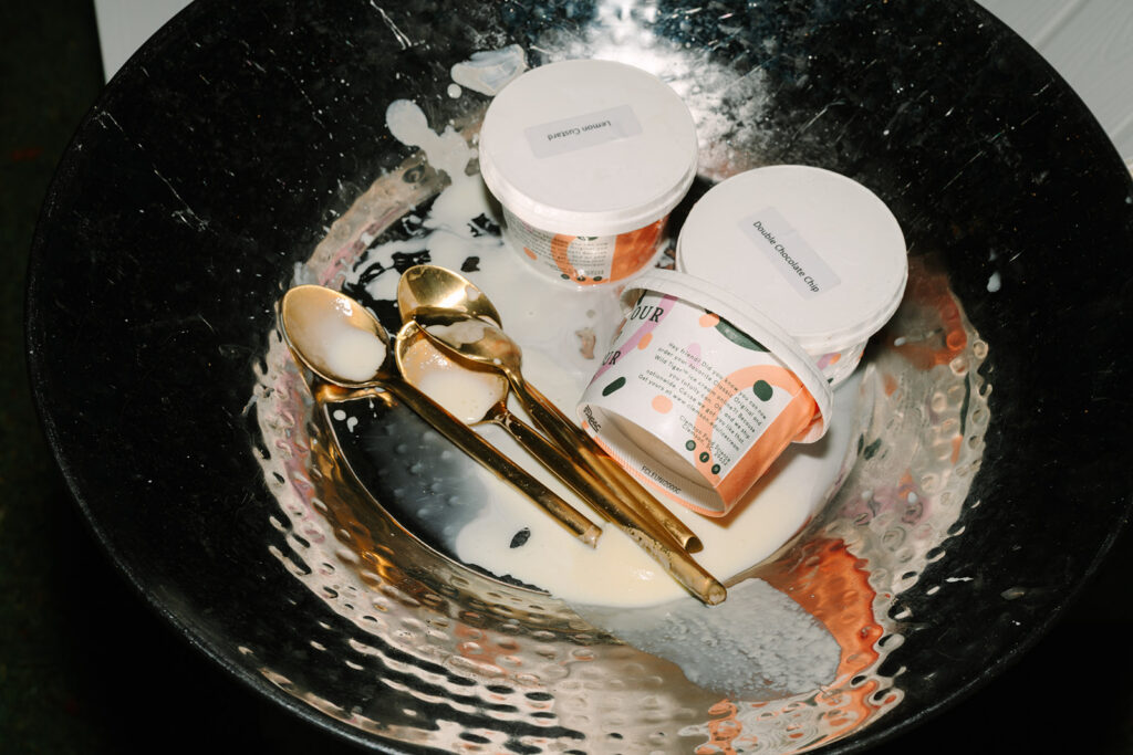 Gold spoons and candle jars rest inside a silver tray, photographed as refined reception details from a South Carolina wedding photographer.
