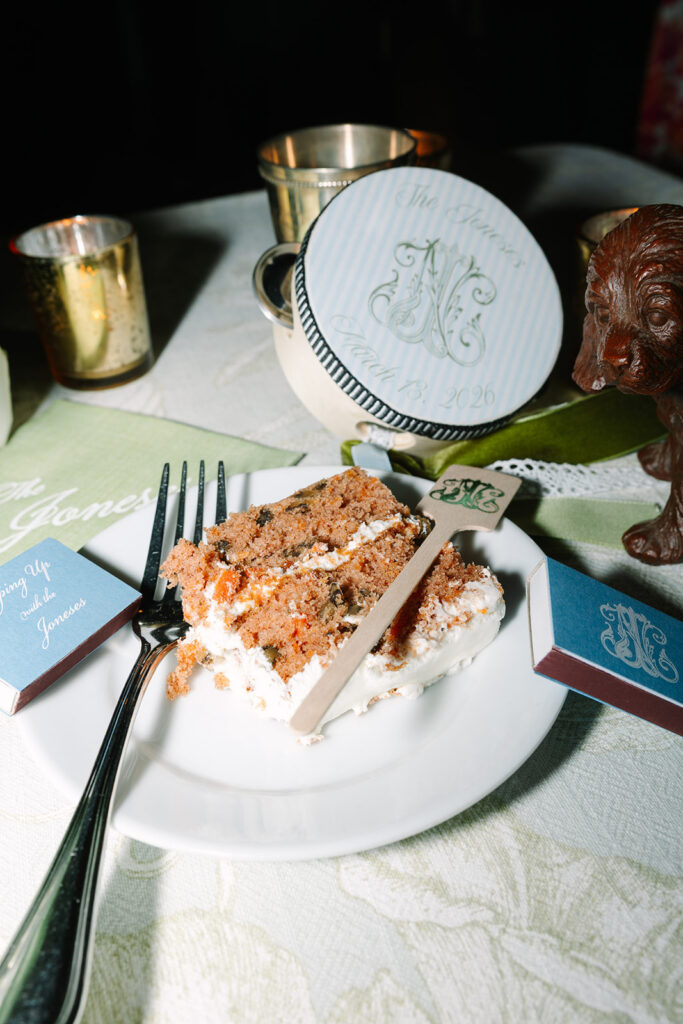 Monogrammed cookies, metallic cups, and printed paper goods rest on a reception table, styled as elevated wedding details for a classic Charleston wedding.
