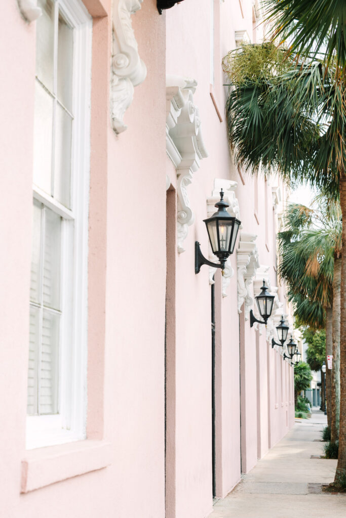 Downtown Charleston senior portrait at the historic Mills hotel. Pink Hotel with black lanterns and palmetto trees photography by Stee Garman Photography.