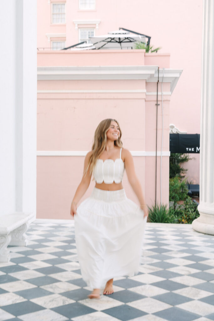 Senior photographed in downtown charleston. Motion blur photos of senior skipping on Iconic checkered flooring of Hiberian Hall. Photographed by Stee Garman Photography.