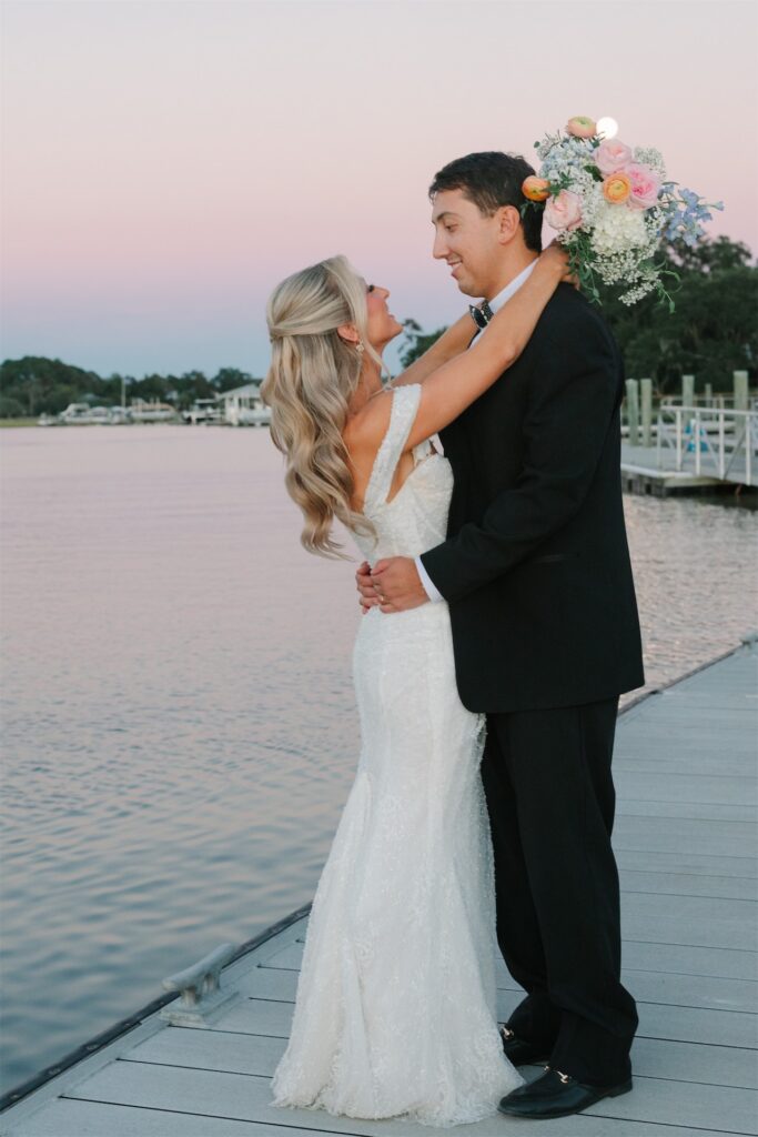 Bride and groom embracing on the dock overlooking the Stono River at The Island House