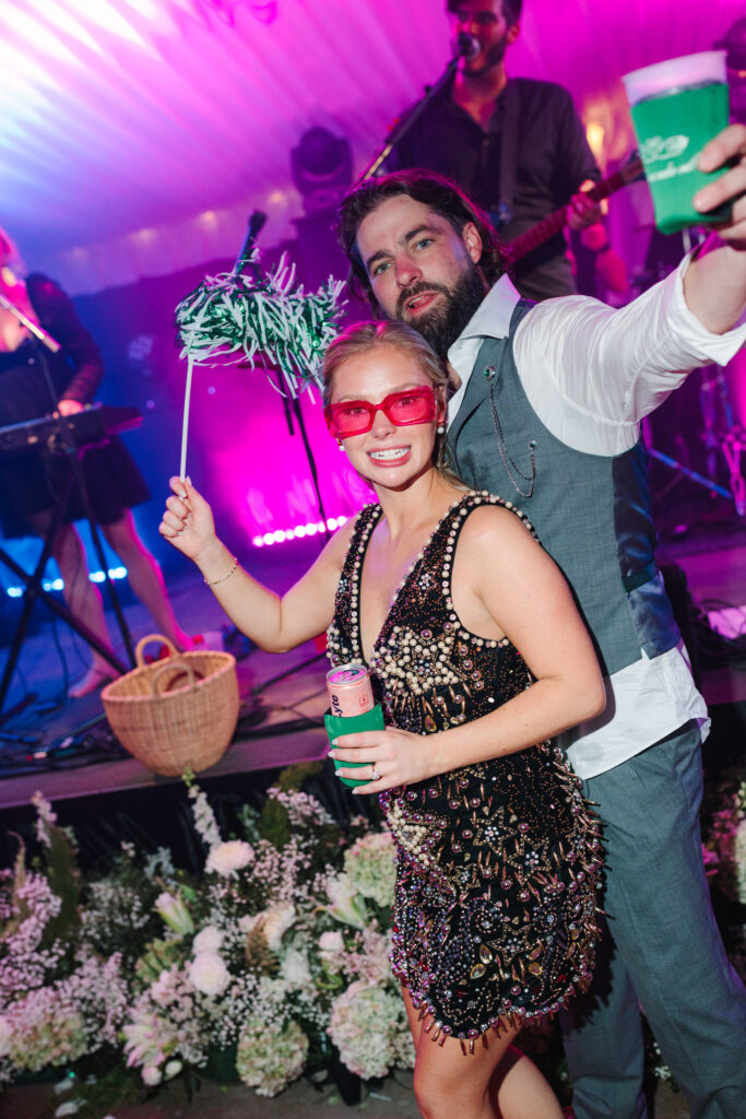 Savannah in her black reception dress dancing with Taylor under colorful lights at The Island House wedding