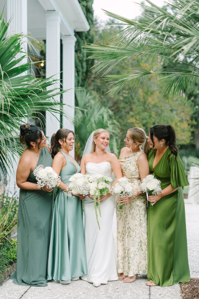 Bride with bridesmaids in green and floral dresses at The Island House Charleston wedding venue