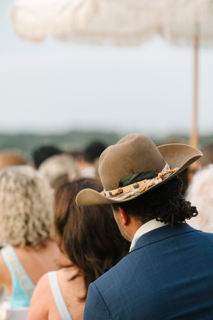 Wedding guest in a brown cowboy hat during the outdoor ceremony at The Island House