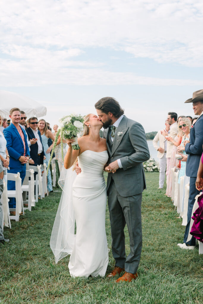 Savannah and Taylor celebrating as they walk down the aisle at The Island House wedding venue in Charleston